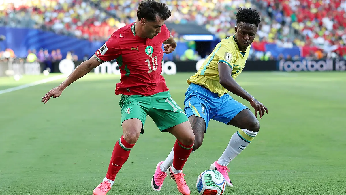 EAST RUTHERFORD, NEW JERSEY - JUNE 13: Brahim Diaz #10 of Morocco holds off Vinicius Junior #7 of Brazil during the FIFA World Cup 2026 Group C match between Brazil and Morocco at New York New Jersey Stadium on June 13, 2026 in East Rutherford, New Jersey. (Photo by Dan Mullan/Getty Images)