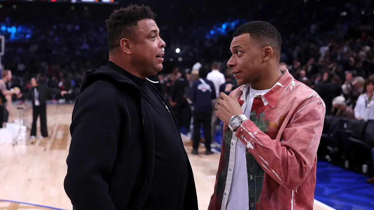 PARIS, FRANCE - JANUARY 11: Footballer, Kylian Mbappe of France and former football player, Ronaldo #R9 speak at half time during NBA match between Brooklyn Nets and Cleveland Cavaliers at The Accor Arena on January 11, 2024 in Paris, France. (Photo by Dean Mouhtaropoulos/Getty Images)
