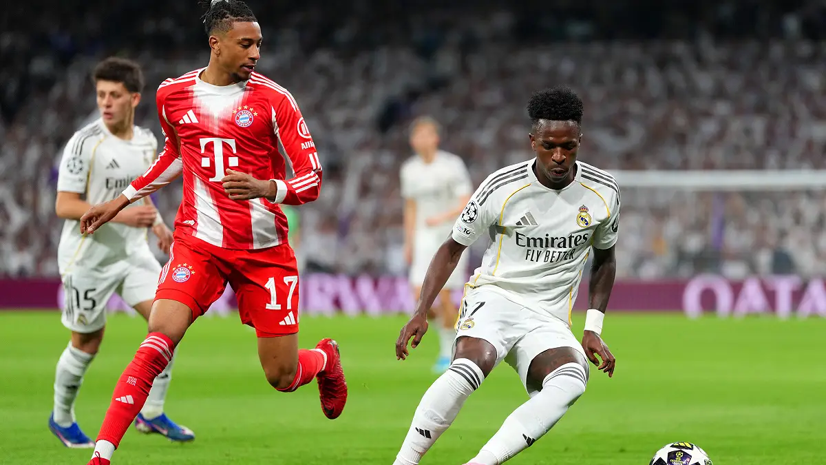 MADRID, SPAIN - APRIL 07: Vinicius Junior of Real Madrid is challenged by Michael Olise of FC Bayern Munich during the UEFA Champions League 2025/26 Quarter-Final First Leg match between Real Madrid CF and FC Bayern München at Estadio Santiago Bernabeu on April 07, 2026 in Madrid, Spain. (Photo by Aitor Alcalde/Getty Images)