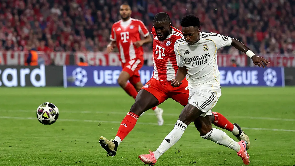 MUNICH, GERMANY - APRIL 15: Dayot Upamecano of Bayern Munich challenges Vinicius Junior of Real Madrid during the UEFA Champions League 2025/26 Quarter-Final Second Leg match between FC Bayern München and Real Madrid CF at Football Arena Munich on April 15, 2026 in Munich, Germany. (Photo by Lars Baron/Getty Images)